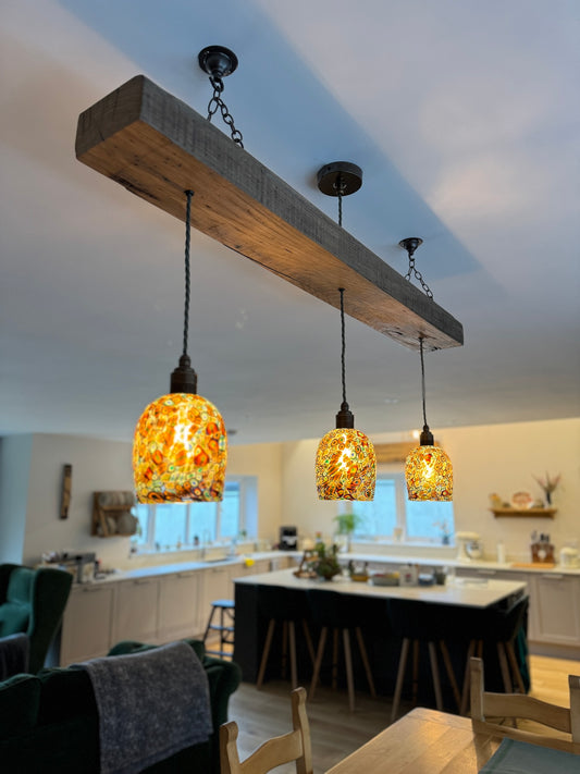 Oak beam chandelier over a dining table with murano glass shades